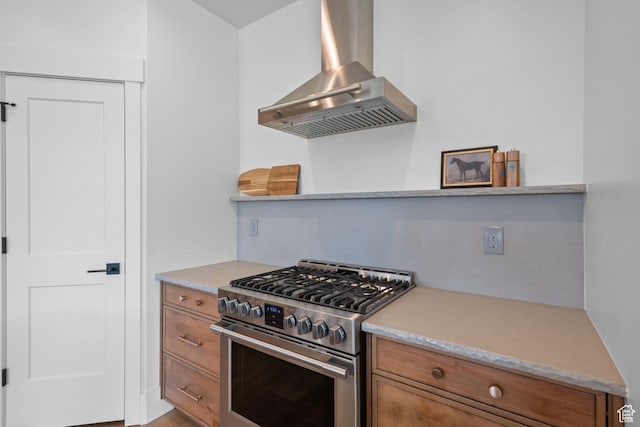 3232 E 5225 N, Eden, UT 84310 - kitchen featuring wall chimney exhaust hood, high end range, brown cabinets, and light countertops