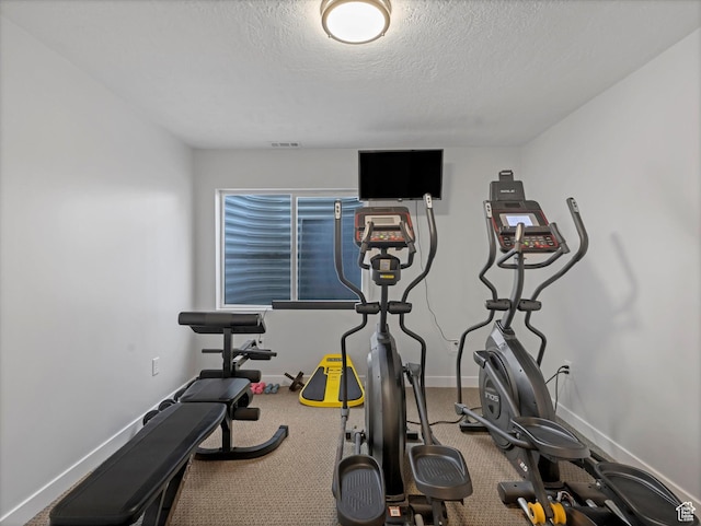 exercise area with baseboards and a textured ceiling
