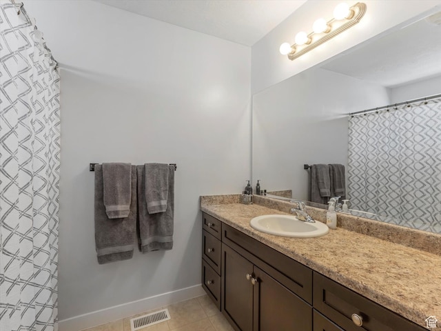 full bathroom with vanity, tile patterned flooring, and baseboards