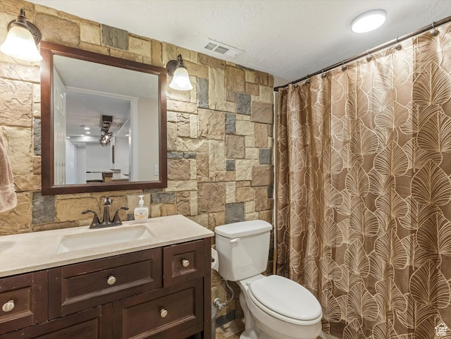 bathroom with toilet, vanity, a shower with curtain, and a textured ceiling
