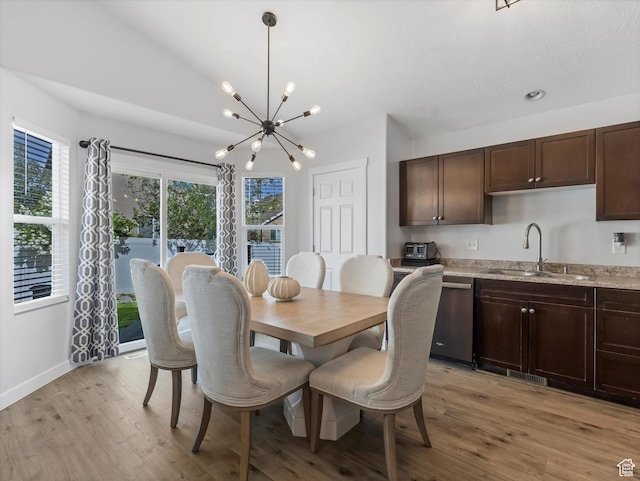 dining room featuring a chandelier, light wood-type flooring, and baseboards