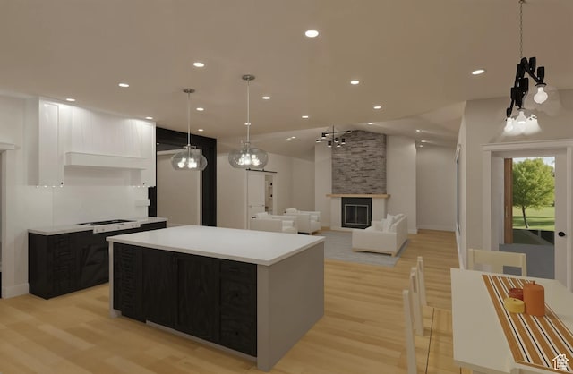 268 W 3400 S Unit 5, Nibley, UT 84321 - kitchen with a center island, light wood-style floors, light countertops, a fireplace, and recessed lighting