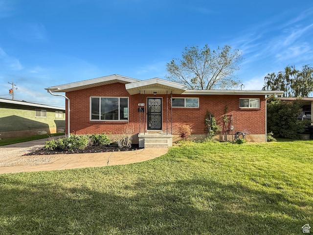 ranch-style home featuring a front lawn and brick siding