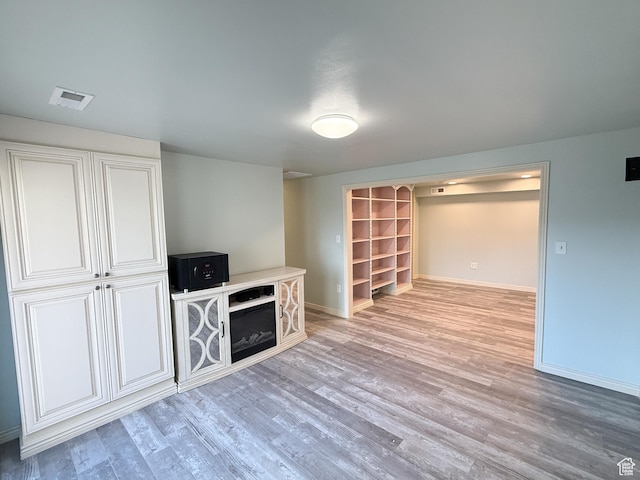 unfurnished living room with baseboards and light wood finished floors