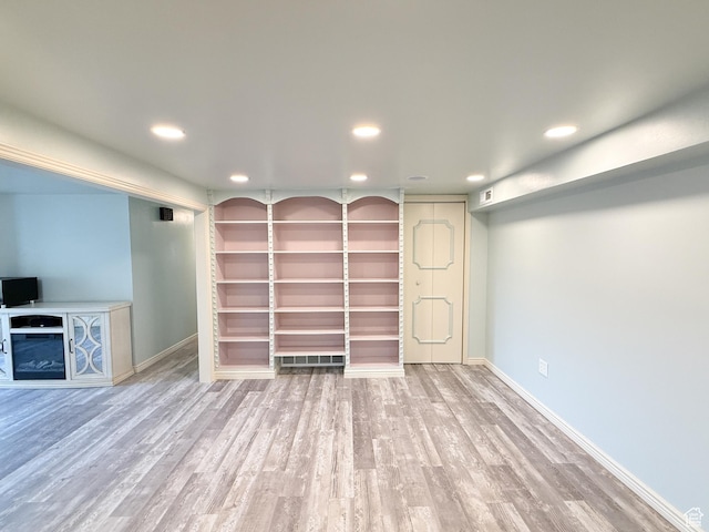 unfurnished living room with recessed lighting, wood finished floors, baseboards, and a fireplace