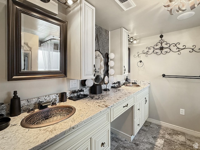 bathroom with double vanity and baseboards