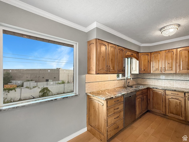 kitchen featuring stainless steel dishwasher, light wood-style floors, a sink, brown cabinets, and light stone counters