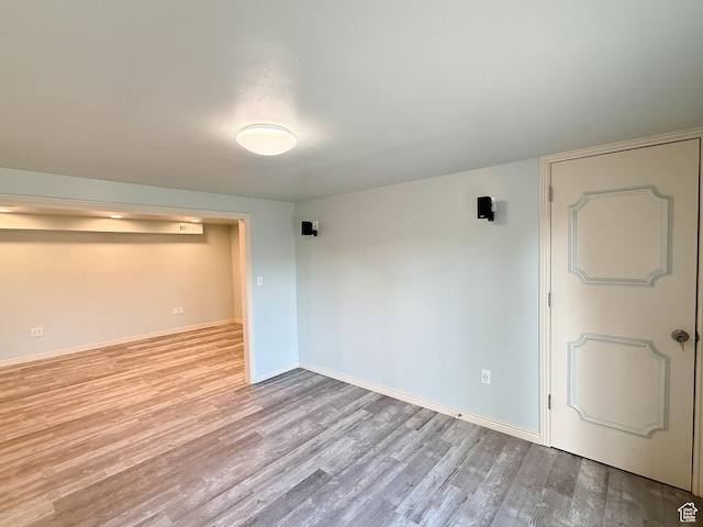 spare room featuring wood finished floors and baseboards