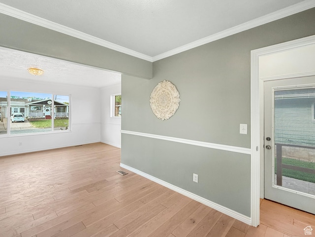 spare room with baseboards, wood finished floors, and ornamental molding