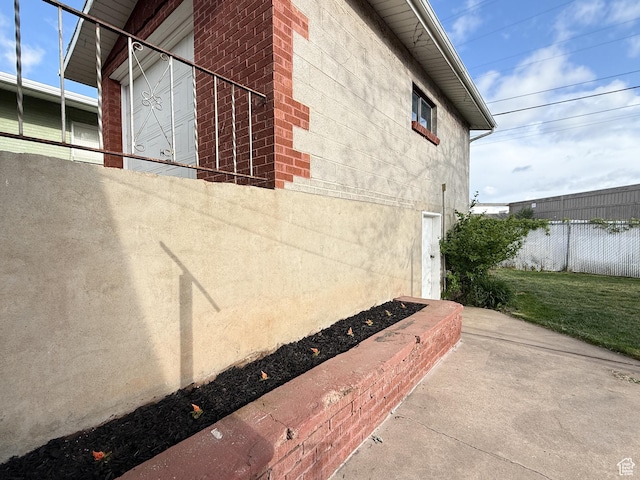 view of side of property featuring fence and stucco siding