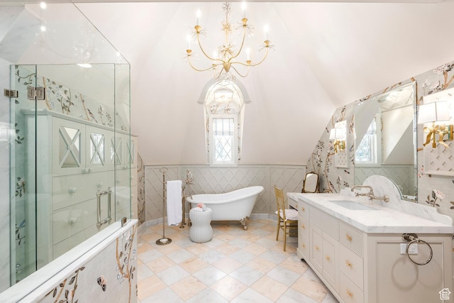 bathroom featuring a chandelier, vaulted ceiling, healthy amount of natural light, a wainscoted wall, and a shower with door