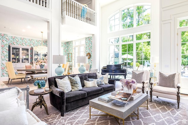 living room featuring plenty of natural light, a high ceiling, and wallpapered walls