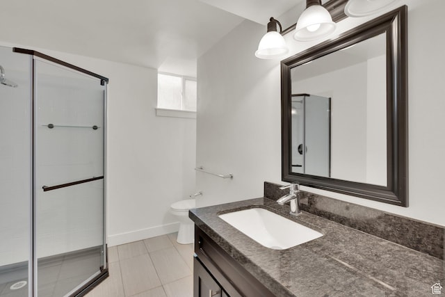 bathroom with a shower stall, toilet, tile patterned floors, vanity, and baseboards
