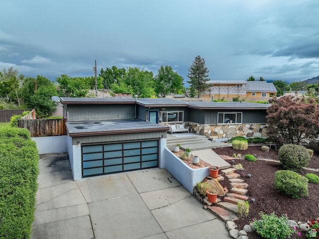 view of front of home featuring fence and concrete driveway