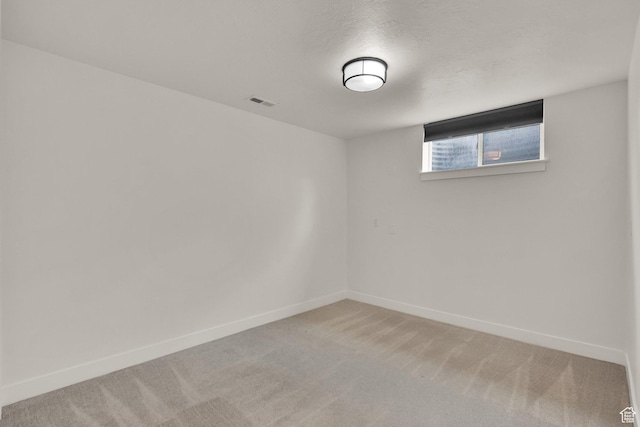 unfurnished room featuring light carpet and baseboards