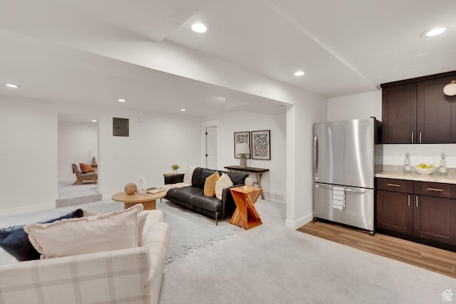 living room featuring recessed lighting, baseboards, and light wood-type flooring