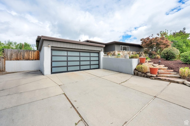 view of front of home with fence, concrete driveway, and a garage