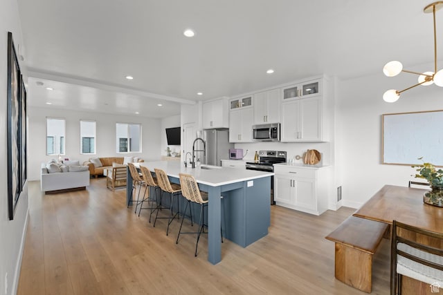 422 S 700 W, American Fork, UT 84003 - kitchen featuring stainless steel appliances, light wood finished floors, a kitchen breakfast bar, white cabinetry, and recessed lighting
