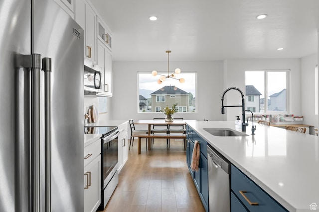 422 S 700 W, American Fork, UT 84003 - kitchen with stainless steel appliances, a sink, blue cabinets, light countertops, and recessed lighting