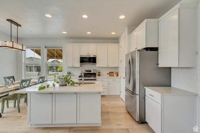 1343 N 3350 W, Provo, UT 84601 - kitchen featuring appliances with stainless steel finishes, light countertops, white cabinetry, recessed lighting, and light wood-style flooring