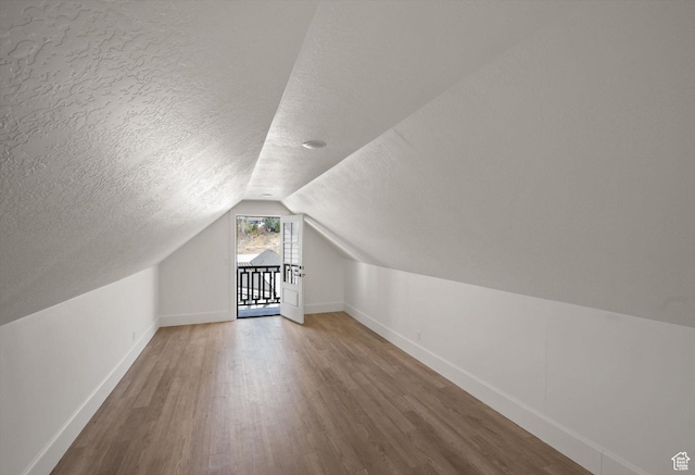 1565 N Overolook Ct, Farmington, UT 84025 - additional living space with a textured ceiling, baseboards, wood finished floors, and lofted ceiling