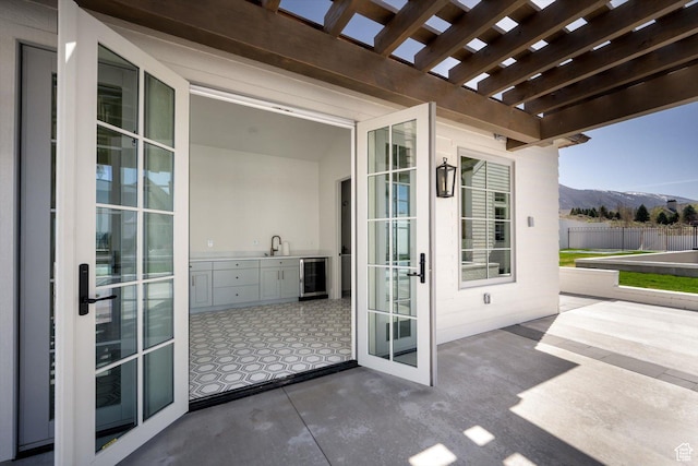 1565 N Overolook Ct, Farmington, UT 84025 - view of patio / terrace with wine cooler, a mountain view, a pergola, and fence
