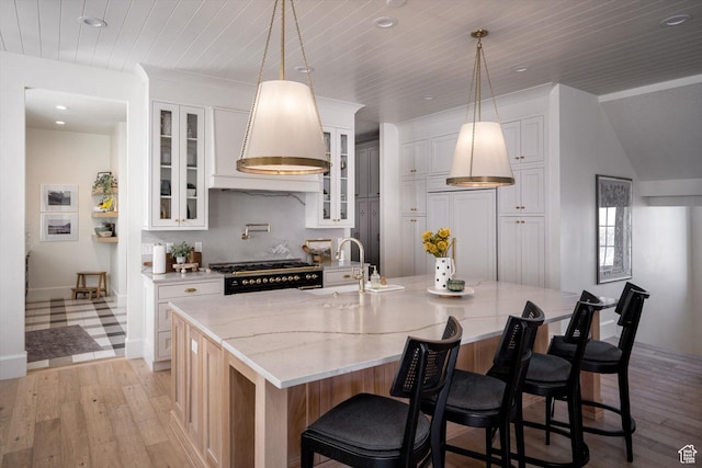 1565 N Overolook Ct, Farmington, UT 84025 - kitchen with a sink, range hood, gas range, light wood finished floors, and a center island with sink