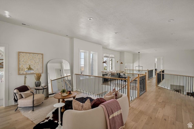 1565 N Overolook Ct, Farmington, UT 84025 - living area with light wood-type flooring, arched walkways, an upstairs landing, and a textured ceiling