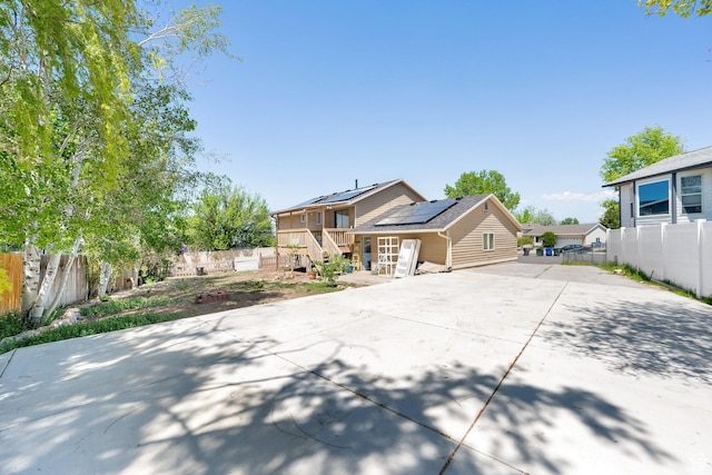 4242 S 6530 W, West Valley City, UT 84128 - view of front facade with concrete driveway, solar panels, and fence