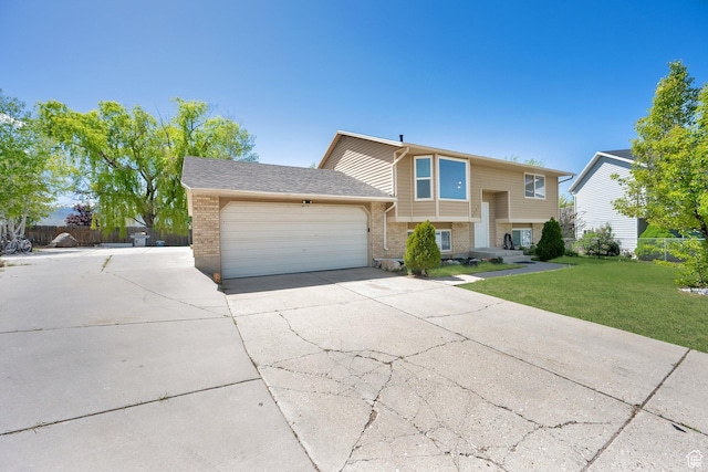 4242 S 6530 W, West Valley City, UT 84128 - bi-level home with an attached garage, driveway, and brick siding