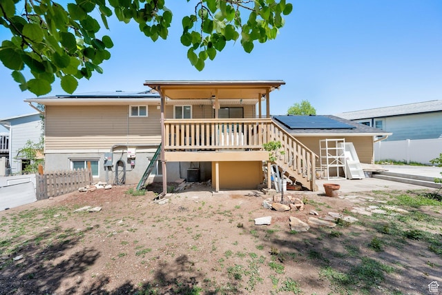 4242 S 6530 W, West Valley City, UT 84128 - back of property with solar panels, stairway, fence, a wooden deck, and central AC unit