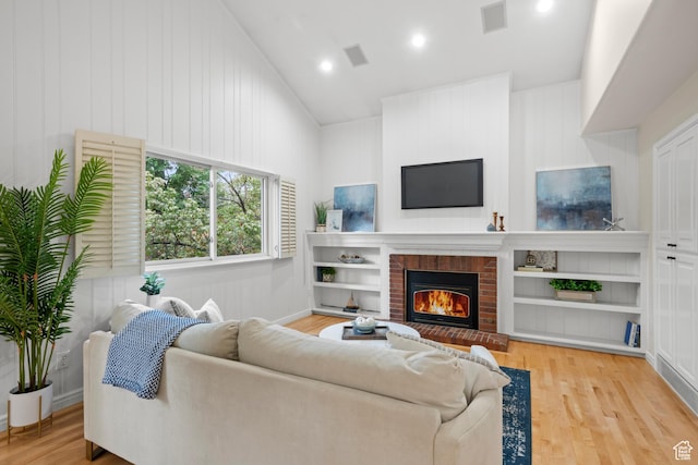 living area featuring a fireplace, wood finished floors, recessed lighting, vaulted ceiling, and baseboards