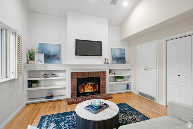 living room featuring wood finished floors, a fireplace, and baseboards