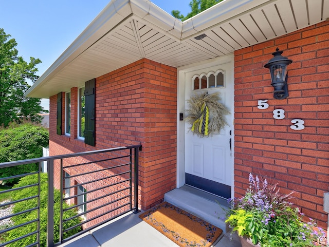 entrance to property featuring brick siding