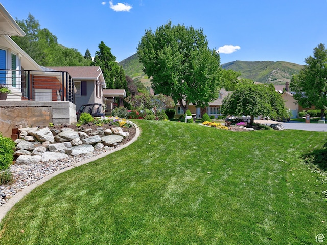 view of green lawn with a mountain view