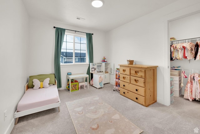 carpeted bedroom featuring a spacious closet, a closet, and baseboards