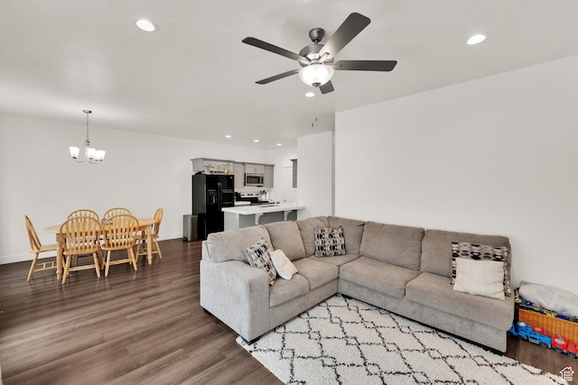 living room with a chandelier, ceiling fan, wood finished floors, recessed lighting, and baseboards