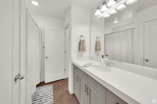 full bathroom with wood finished floors, vanity, and recessed lighting