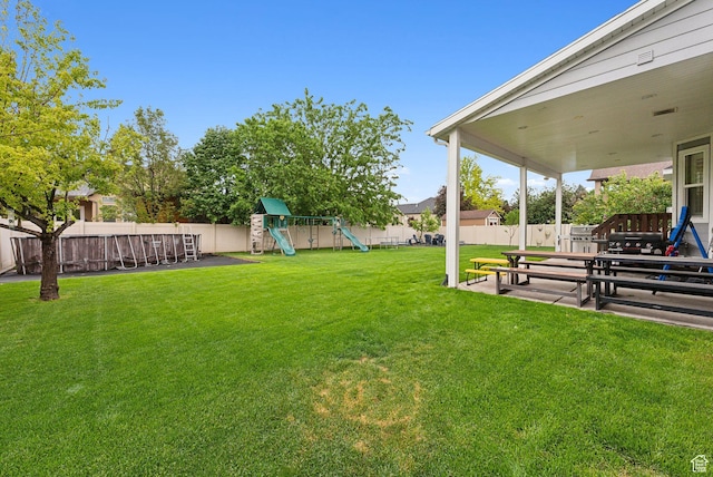 view of yard featuring a playground and a patio
