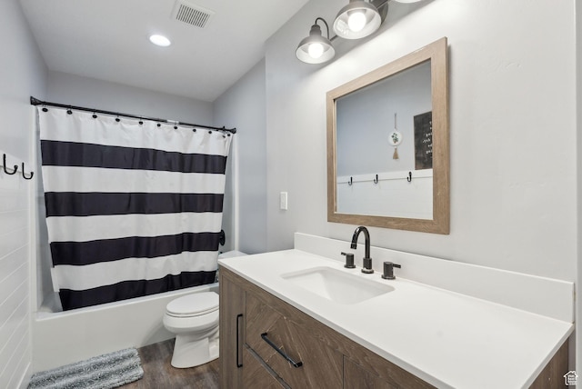 bathroom featuring wood finished floors, toilet, shower / bathtub combination with curtain, and vanity