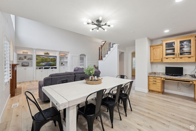 dining area with arched walkways, light wood finished floors, a chandelier, recessed lighting, and baseboards