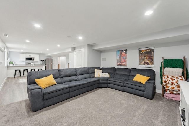 living area featuring recessed lighting, light colored carpet, baseboards, and light wood-style floors
