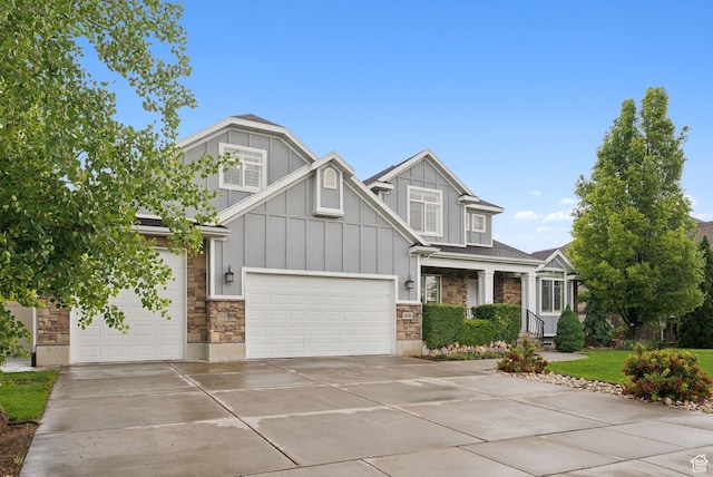 craftsman-style home featuring stone siding, board and batten siding, driveway, and an attached garage