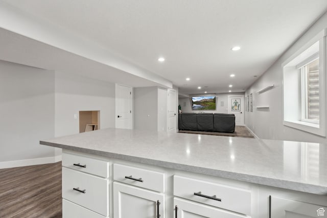 kitchen with recessed lighting, light countertops, white cabinets, dark wood-style floors, and baseboards