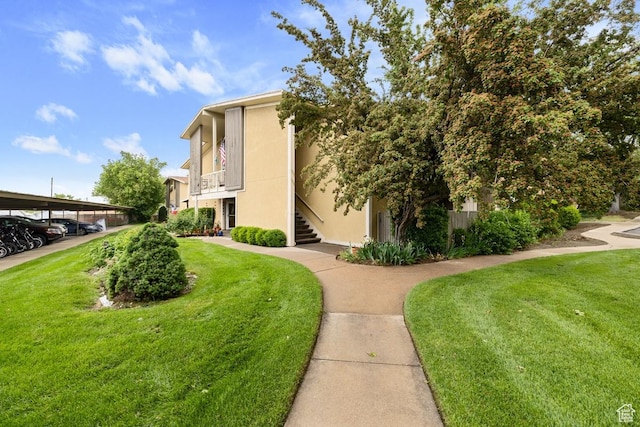 view of property exterior featuring a lawn, stucco siding, and covered parking