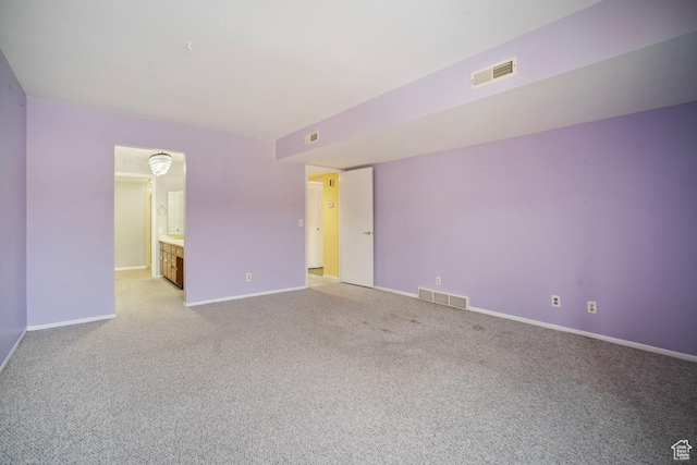 spare room featuring baseboards and light colored carpet