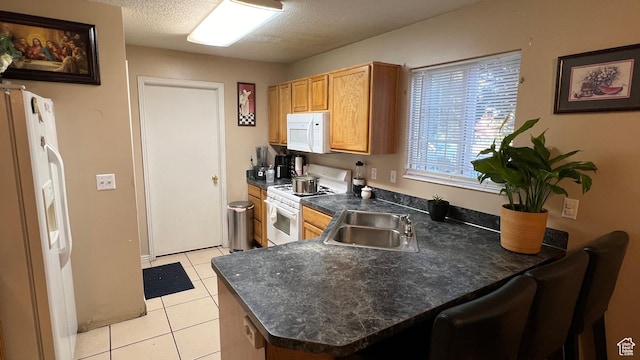 2788 Gettysburg Way, Ogden, UT 84401 - kitchen with white appliances, dark countertops, a peninsula, light tile patterned floors, and a sink