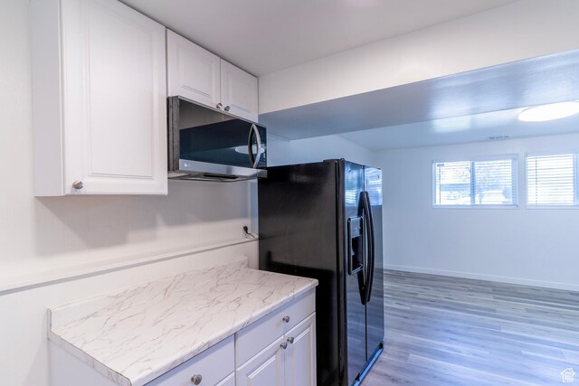 4740 S 3040 W, Taylorsville, UT 84129 - kitchen featuring stainless steel microwave, black fridge with ice dispenser, white cabinetry, and light wood-style floors