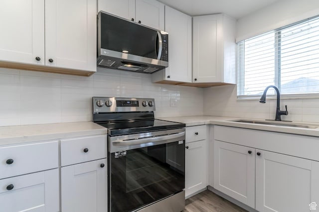 4740 S 3040 W, Taylorsville, UT 84129 - kitchen with appliances with stainless steel finishes, a sink, decorative backsplash, light countertops, and white cabinetry