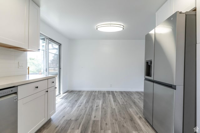 4740 S 3040 W, Taylorsville, UT 84129 - kitchen featuring stainless steel appliances, white cabinets, light wood finished floors, and tasteful backsplash